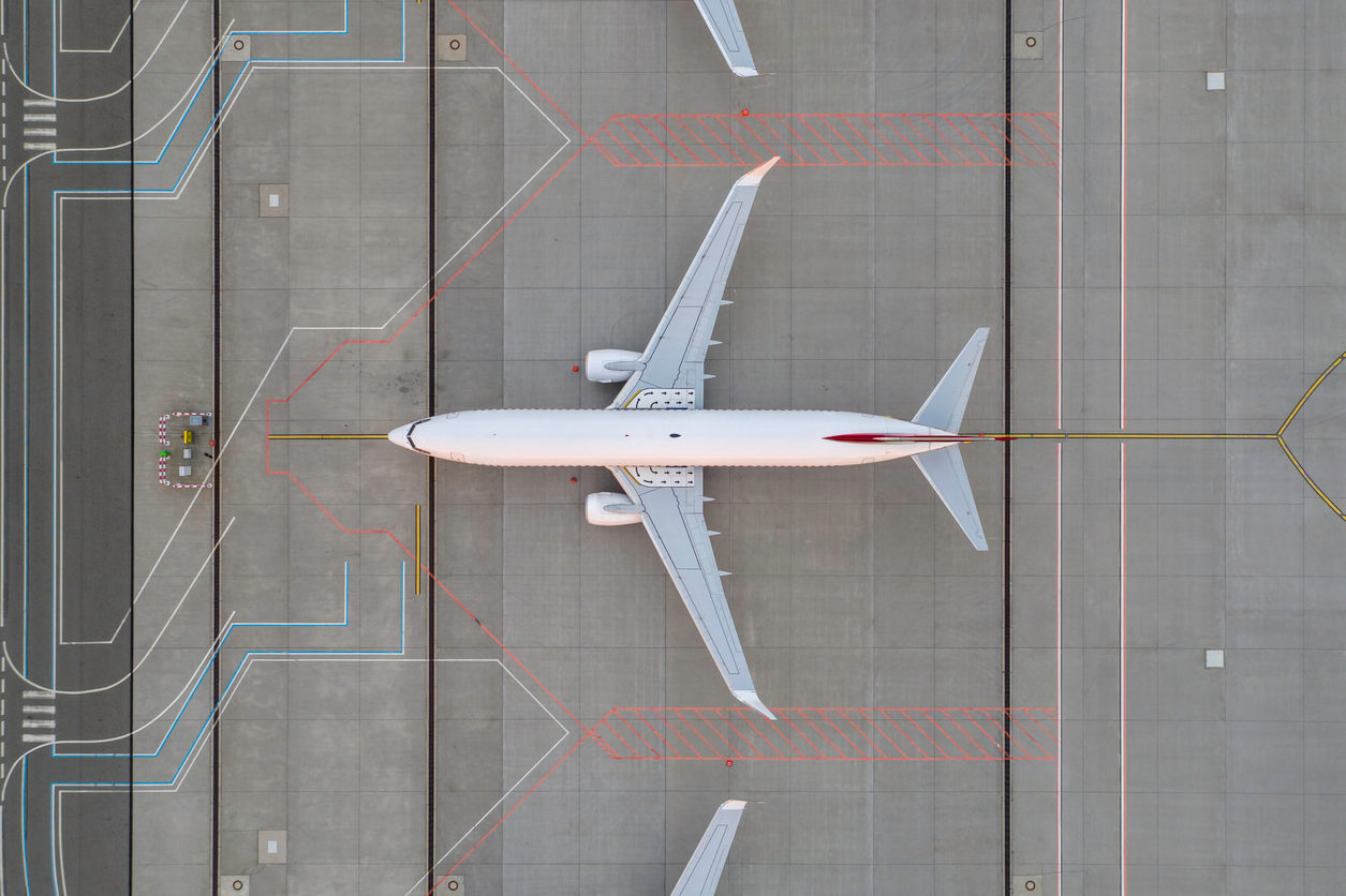 Top down view on comercial airplane in the parking lot of the airport apron